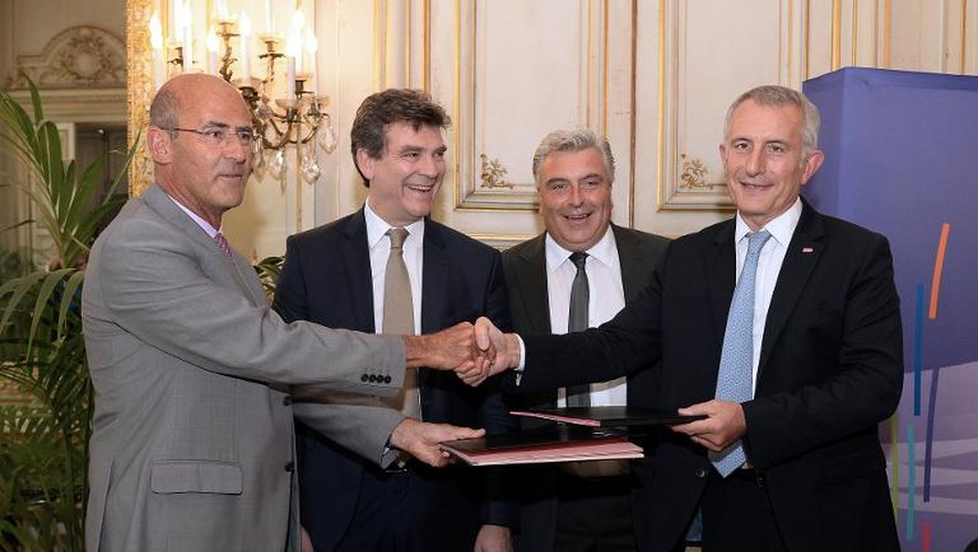 Le PDG d'Alstom Patrick Kron (g) sert la main du président de la SNCF Guillaume Pepy (d), aux côtés du ministre du Redressement productif Arnaud Montebourg (2eg) et du ministre des Transports Frédéric Cuvillier, lors de la signature de l'ac