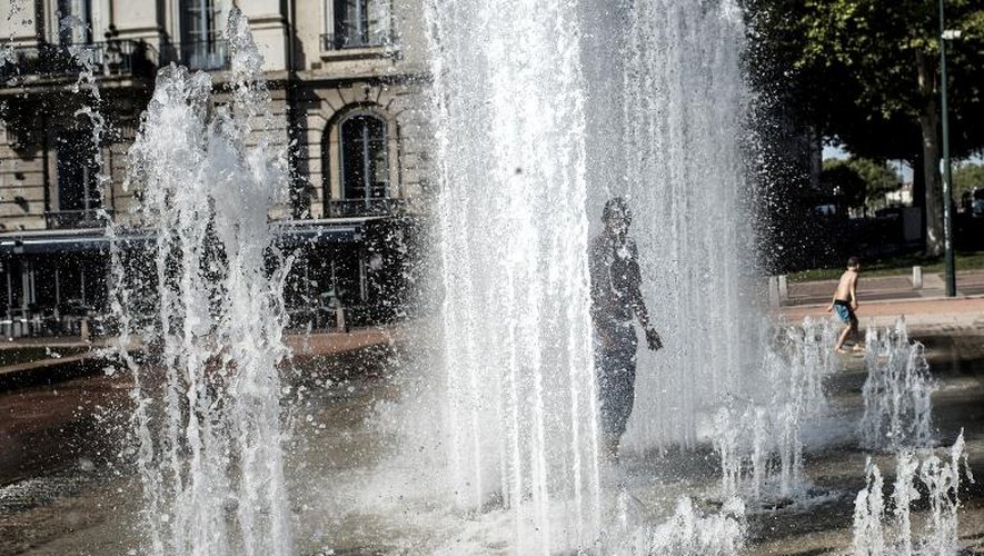 Un homme se rafraîchit sous une fontaine le 26 juillet 2013 à Lyon