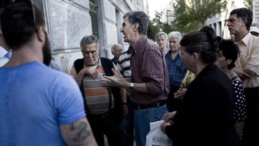 Un retraité s'énerve le 29 juin 2015 devant un bureau de la Banque nationale de Grèce à Athènes avec d'autres retraités attendant leur pension