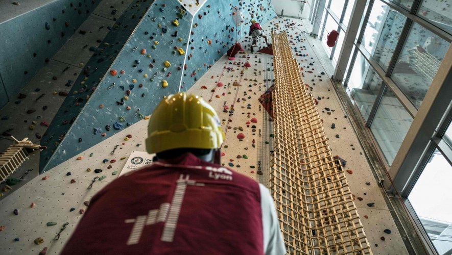 A man belays a team member climbing as he tries to set an official World Record by building the highest Kapla tower, on May 14, 2016 in Lyon. / AFP PHOTO / JEFF PACHOUD