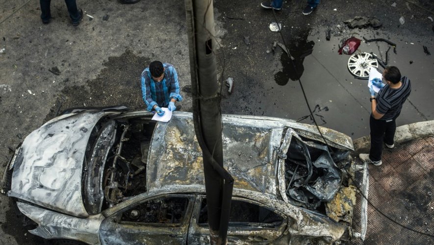 Des détectives examinent le site où une bombe a explosé au passage du convoi du procureur général Hicham Barakat, le 29 juin 2015 au Caire