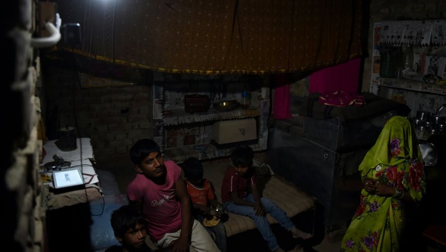 Une famille chez elle, en Inde, à Anandpur, le 23 avril 2016, alors que l'électricité vient enfin d'être installée