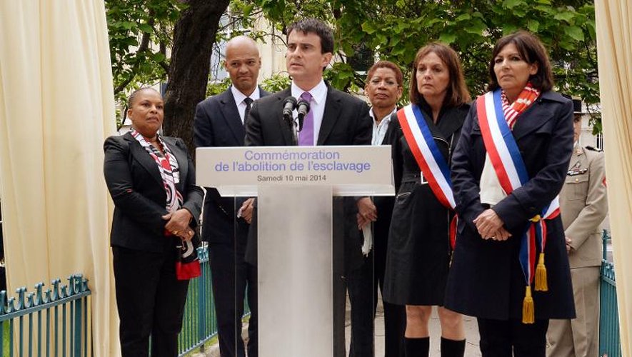 Christiane Taubira (g), ministre de la Justice, le 10 mai 2014 à Paris, aux côtés du Premier ministre Manuel Valls (c), lors de la commération de l'abolition de l'esclavage