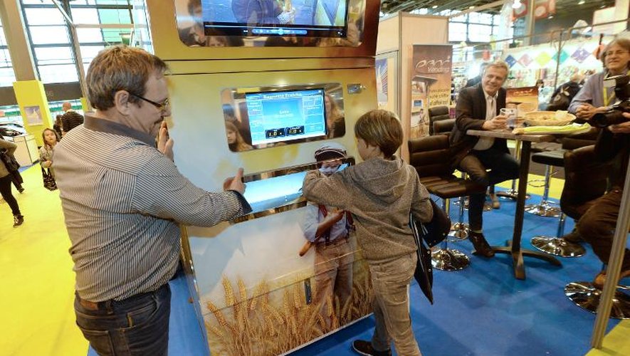 Jean-Louis Hecht (g) aide un garçon à utiliser son invention, la machine  "Pani Vending", le 10 mai 2014 à Paris