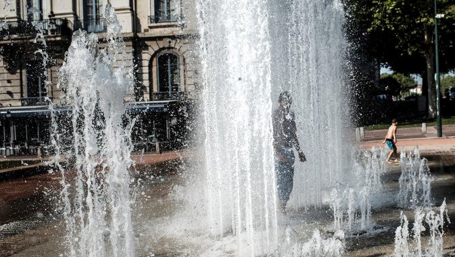 Un homme se rafraichit sous une fontaine le 26 juillet 2013 à Lyon
