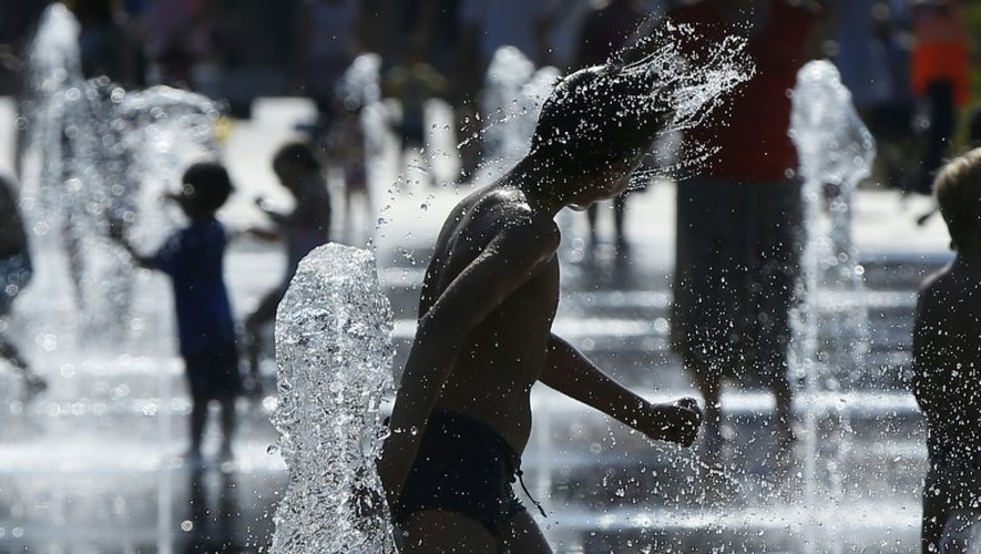 Des enfants se rafraîchissent sous une fontaine le 5 juin 2015 à Nice