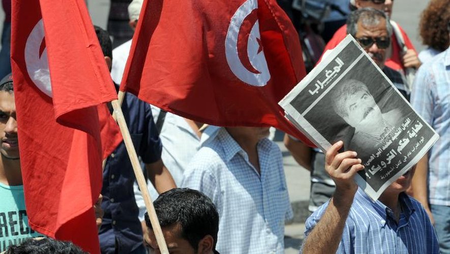 La photo de Mohamed Brahmi à la Une d'un quotidien brandi par des opposants lors d'une manifestation le 26 juillet 2013 à Tunis