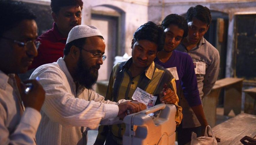 Des assesseurs mettent une machine à vote électronique sous scellés, à Varanasi (Inde), le 12 mai 2014