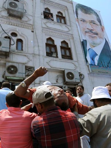 Des partisans du président déchu Mohamed Morsi transportent un homme blessé dans un hôpital de campagne du Caire, le 27 juillet 2013