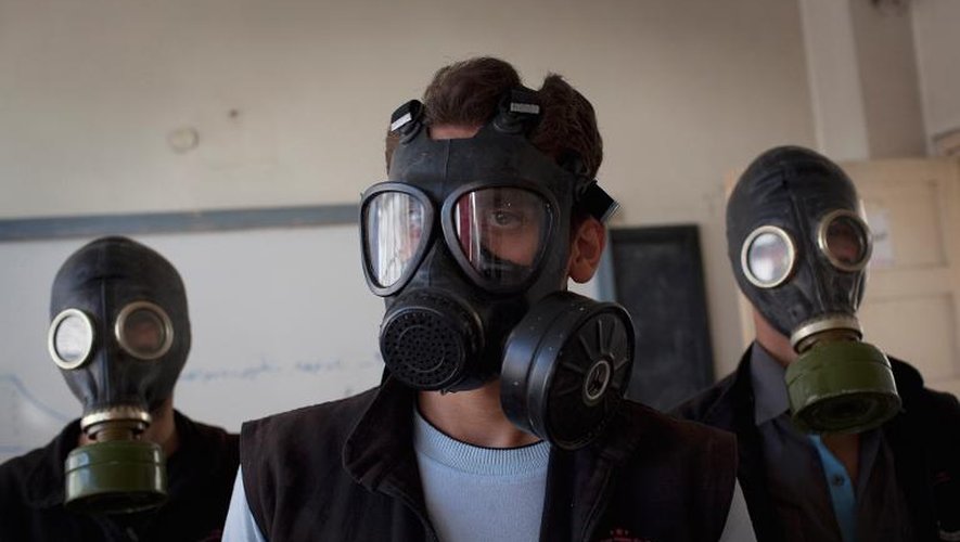 Des hommes portent des masques à gaz lors d'une simulation d'attaque chimique, dans le nord de la Syrie, en mars 2014