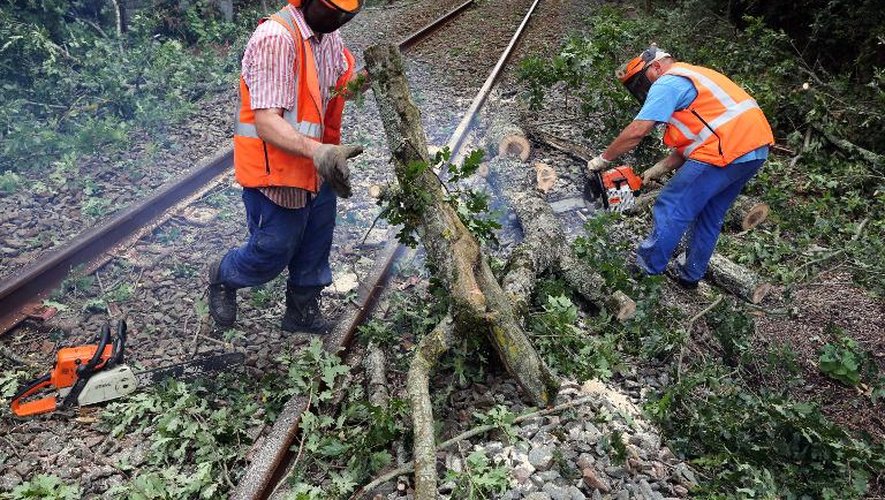Des employés de la SNCF déblaient les voies ferrées le 27 juillet 2013 dans la région de Pauillac dans le sud-ouest