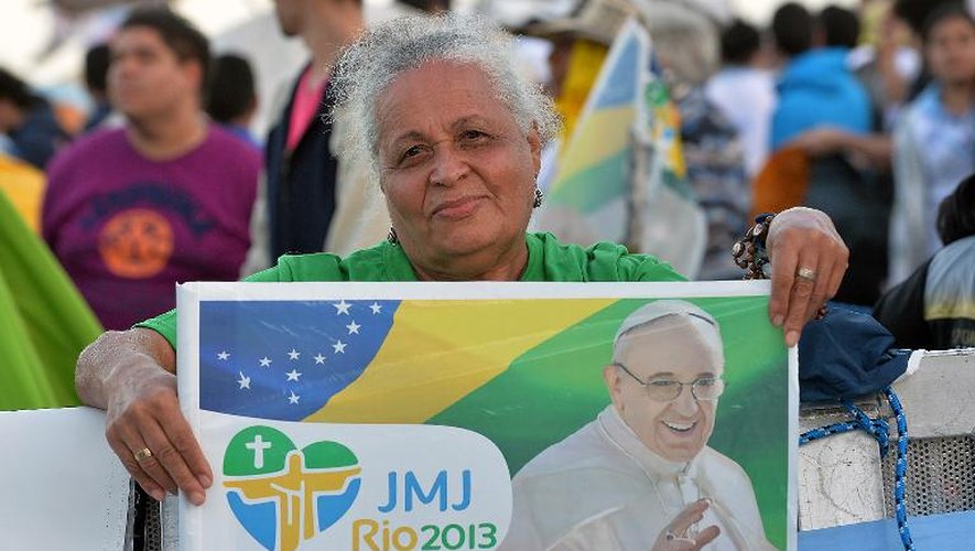 Une fidèle avec la photo du pape le 27 juillet 2013 sur la plage de Copacabana à Rio