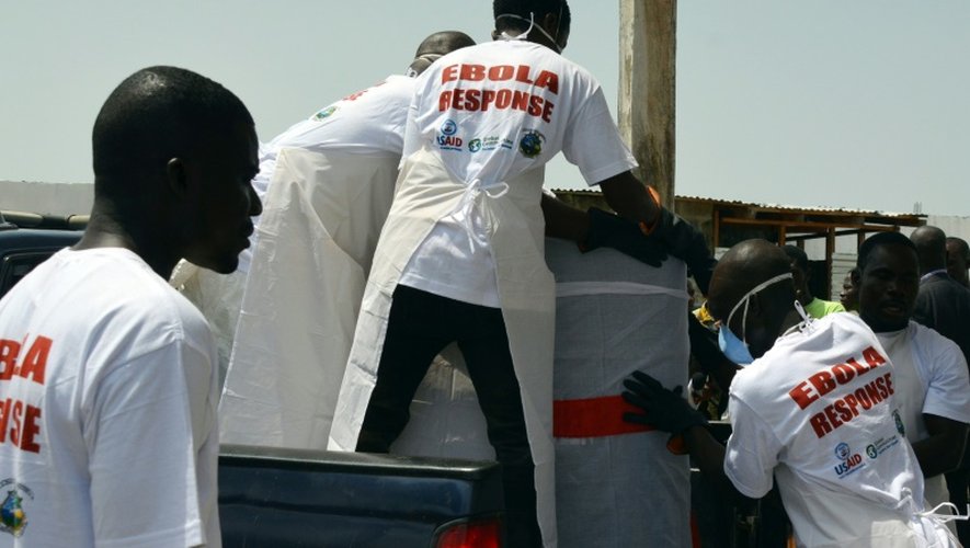 Des employés d'un hôpital font entrer des victimes dans une voiture, le 7 mars 2015 à Monrovia au Libéria
