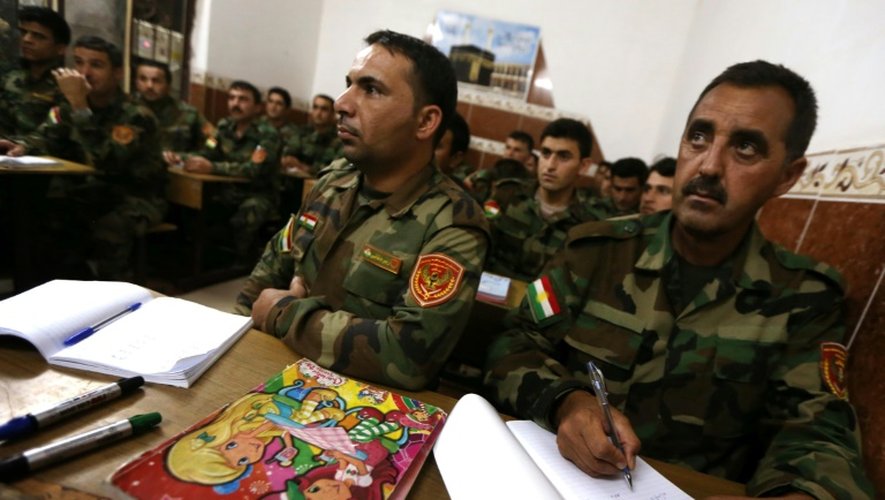 Des combattants kurdes irakiens apprennent à lire et à écrire, le 16 juin 2015, dans une école du village de Bahra, à trois kilomètres de la plus proche des positions du groupe Etat islamique (EI)
