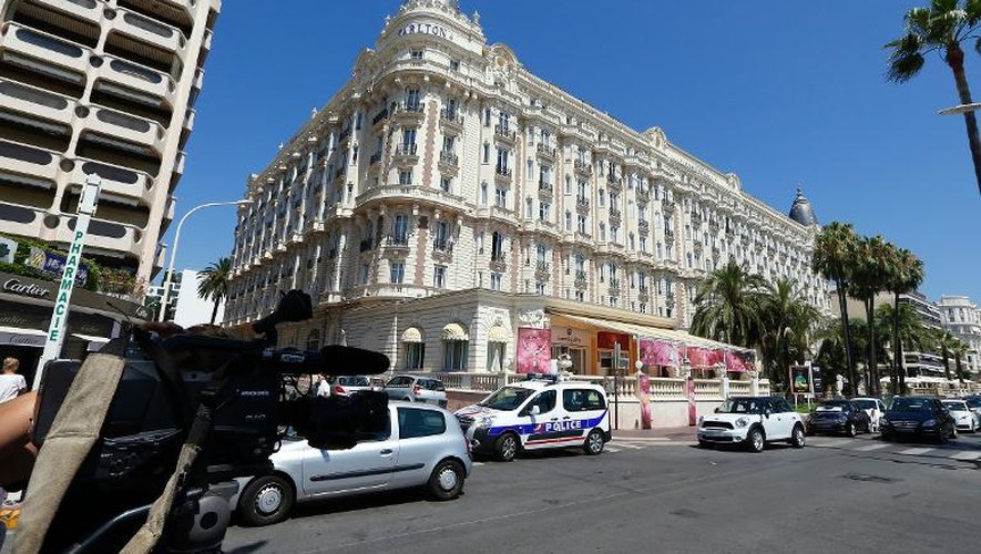 Un journaliste filme la façade de l'hôtel du Carlton, le 28 juillet 2013 à Cannes, où un vol de bijoux s'est produit