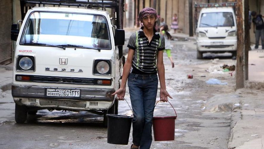 Un homme porte de l'eau dans des seaux à Alep, qui n'a plus d'eau depuis une dizaine de jours, le 10 mai 2014