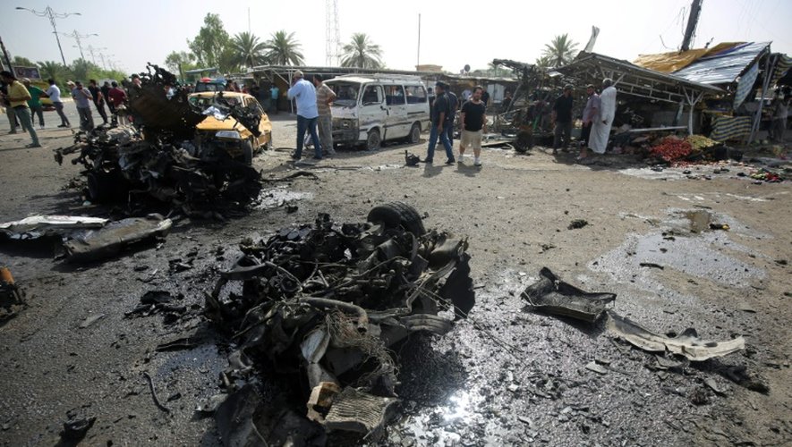 Carcasse de la voiture qui a servi à l'un des attentats suicide dans le quartier de Sadr à Bagdad le 17 mai 2016