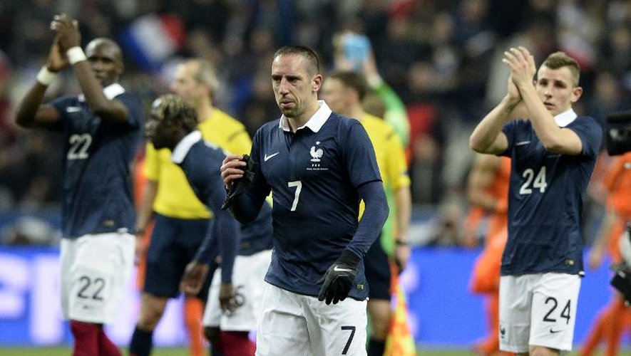 Eliaquim Mangala (g), Franck Ribéry (c) et Lucas Digne (d) viennent saluer les supporteurs français après la victoire en amical contre les Pays-Bas, le 5 mars 2014 au Stade de France