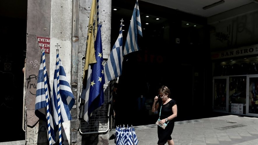 Une femme passe devant des drapeaux grecs dans le centre d'Athènes, le 30 juin 2015