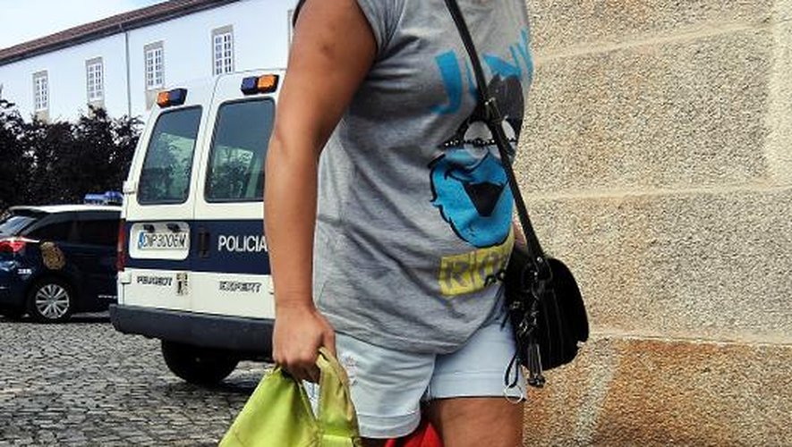 Une femme repart d'une salle de sport où elle est allée récupérer les affaires de victimes du déraillement de train, le 28 juillet 2013 à Saint-Jacques-de-Compostelle