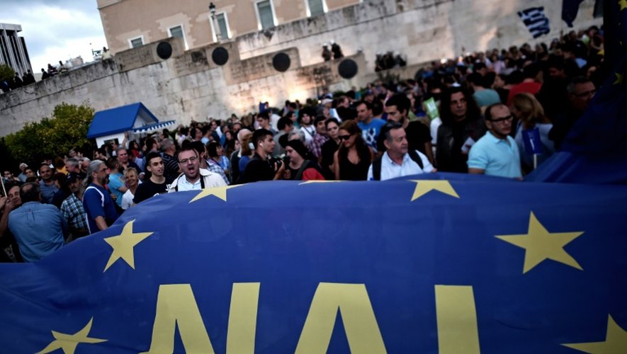 Manifestants pro-européens brandissent un drapeau pronant le "oui" au référendum le 30 juin 2015 devant le Parlement à Athènes
