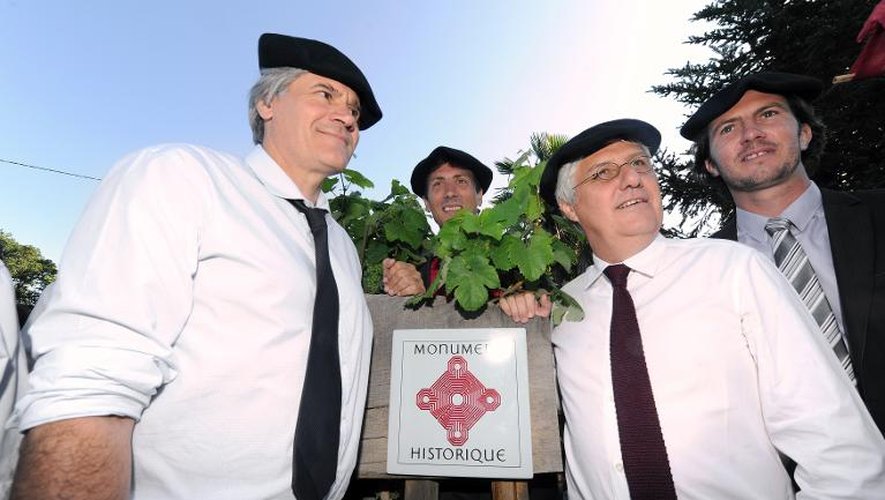 Les ministres de l'Agriculture, Stéphane Le Foll, et de l'Ecologie, Philippe Martin, à côté d'un panneau des Monuments historiques dans le vignoble de Sarragachies, le 30 juillet 2013