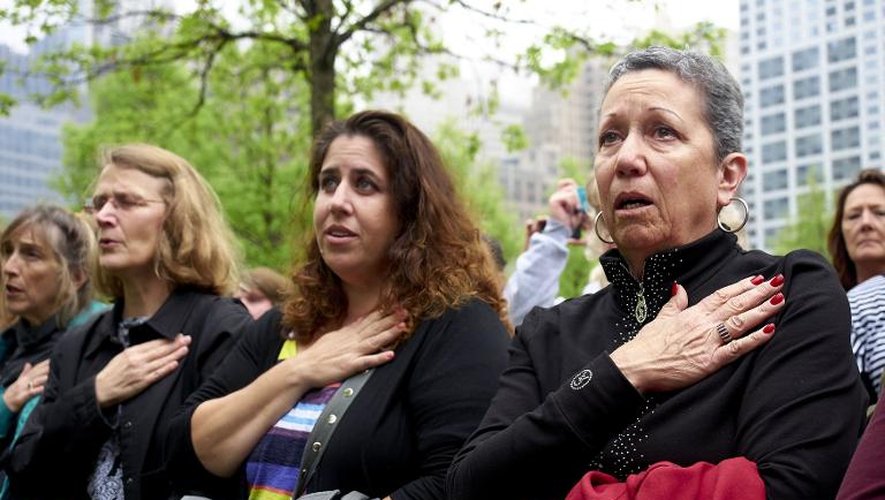 Des femmes regardent un écran retransmettant un discours du président Barack Obama lors de l'inauguration du musée du 11-Septembre, le 15 mai 2014 à New York