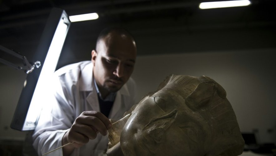 Basem Gehad, archéologue égyptien, nettoie la tête d'un pharaon, le 4 juin 2015, dans un des laboratoires du futur "Grand musée égyptien" toujours en construction