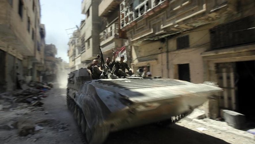 Des soldats de l'armée régulière syrienne patrouillent dans une rue de Homs qui vient d'être reprise aux rebelles, le 31 juillet 2013