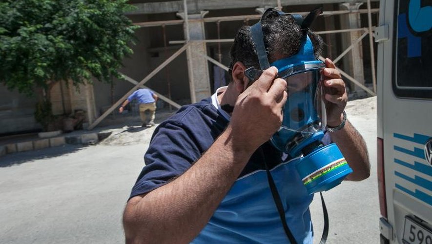 Un conducteur d'ambulance passe un masque à gaz, dans la province d'Idlib, en Syrie, le 21 juin 2013