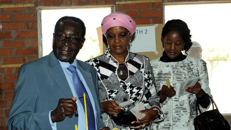 Le président zimbabwéen Robert Mugabe vote avec sa femme et sa fille le 31 juillet 2013 à Harare