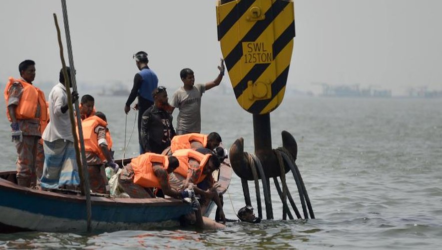 Des sauveteurs sortent un corps de l'eau près de Dhaka le 16 mai 2014