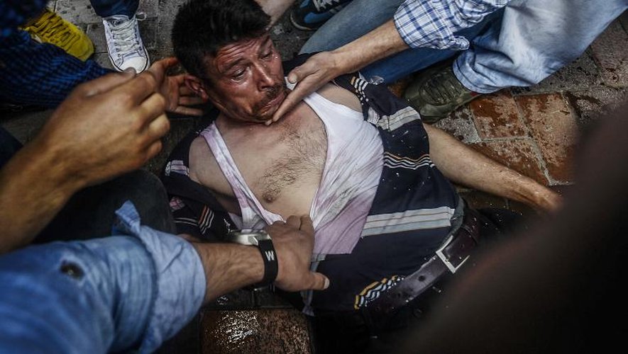Des gens aident un homme blessé par une balle en caoutchouc lancée par la police lors d'une manifestation à Soma le 16 mai 2014