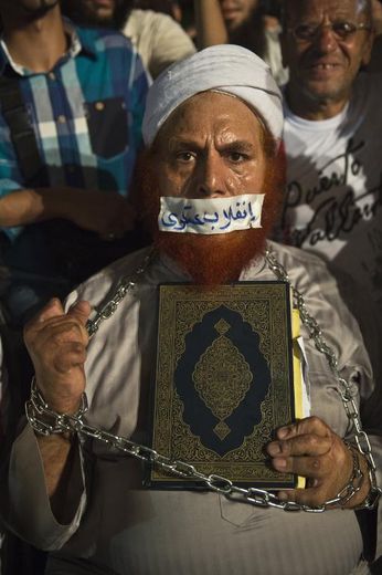 Ce partisan du président égyptien déchu Mohamed Morsi brandit le Coran. Sur le scotch qui barre sa bouche, on peut lire les mots "coup d'Etat militaire"