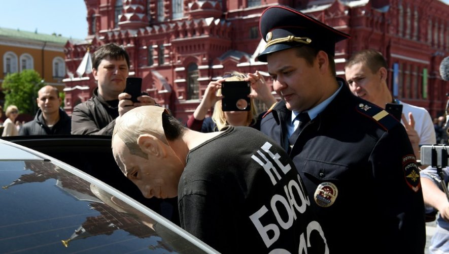 L'artiste russe Roman Roslovtsev porte un masque à l'effigie de Vladimir Poutine et se fait arrêté par la police sur la Place Rouge à Moscou le 14 mai 2016