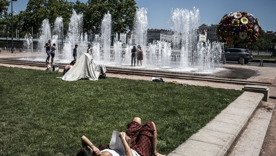 Pause rafraichissante près de fontaines publiques à Lyon, le 30 juin 2015