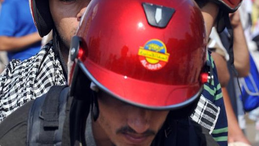 Des partisans de Mohamed Morsi défilent avec des casques de protection sur la tête, le 2 août 2013 au Caire