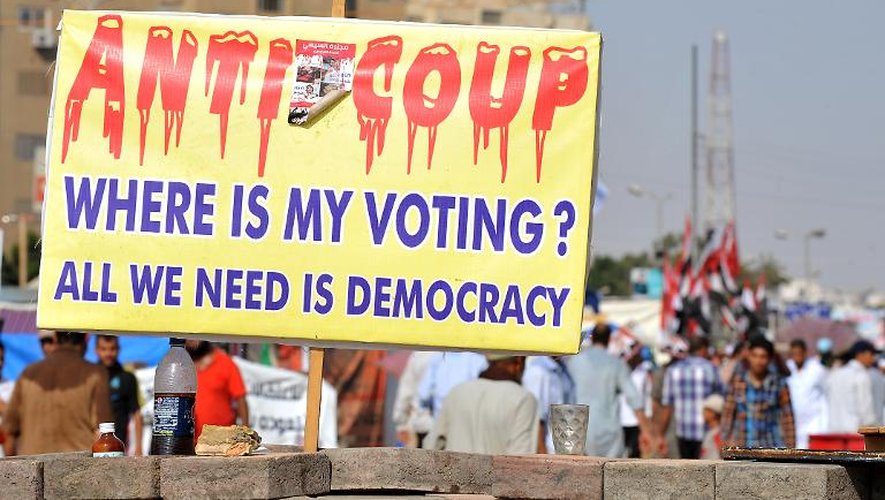 Des pro-Morsi brandissent une pancarte sur laquelle on peut lire "Anti coup d'Etat, où est mon vote? Ce qu'on réclame, c'est la démocratie", le 2 août 2013 au Caire