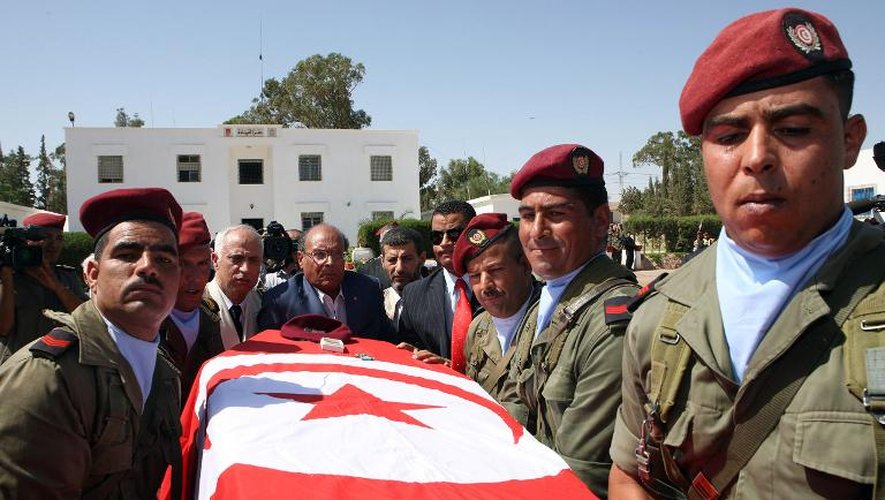 Le président tunisien Moncef Marzouki (c) se tient derrière le cercueil d'un des huit soldats tués par un groupe armé sur le mont Chaambi, le 30 juillet 2013 à Kasserine