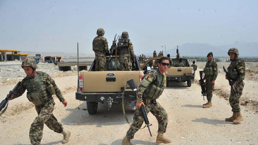 Des soldats afghans se mettent en position lors de combats, le 7 juillet 2013 près de Jalalabad