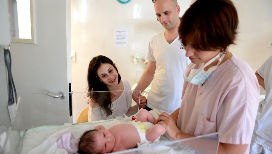 Une sage-femme prend soin du bébé de Hélène Cordeau et de Steven Le Gouallec, après l'accouchement le 2 août 2013 à la Maternité des Lilas, dans la banlieue parisienne