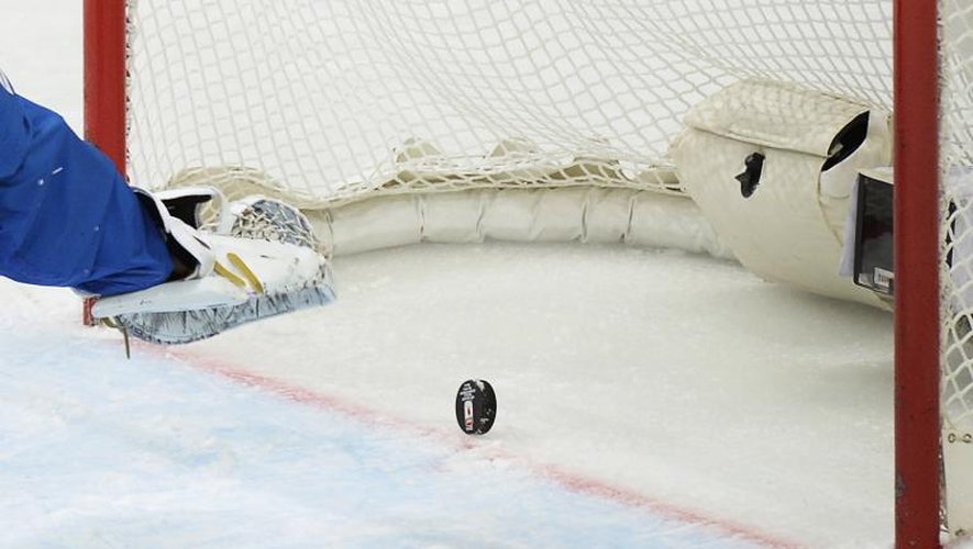 Un palet entre dans un but de hockey sur glace
