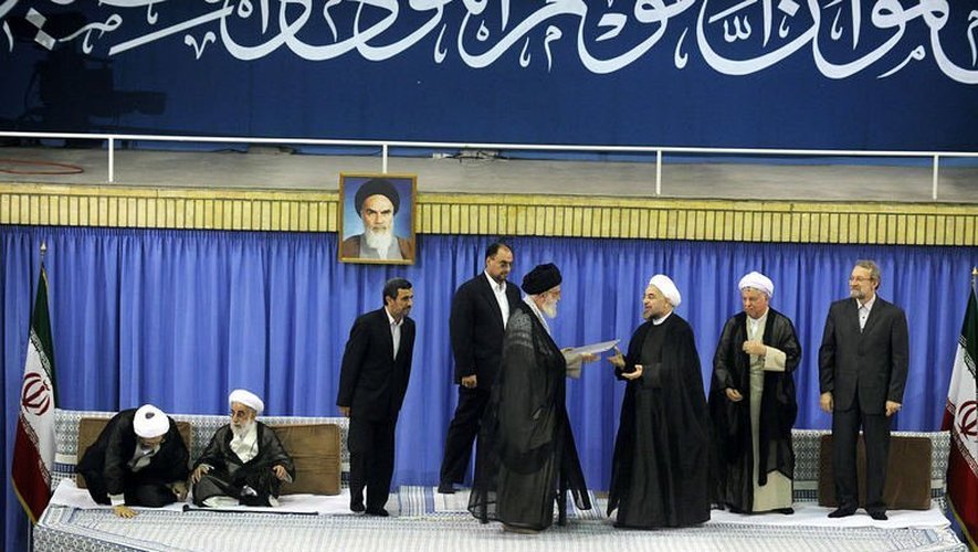 Cette photo remise par les autorités iraniennes montre l'ayatollah Ali Khamenei (5e g) qui investit officiellement Hassan Rohani (3e d) à Téhéran, le 3 août 2013