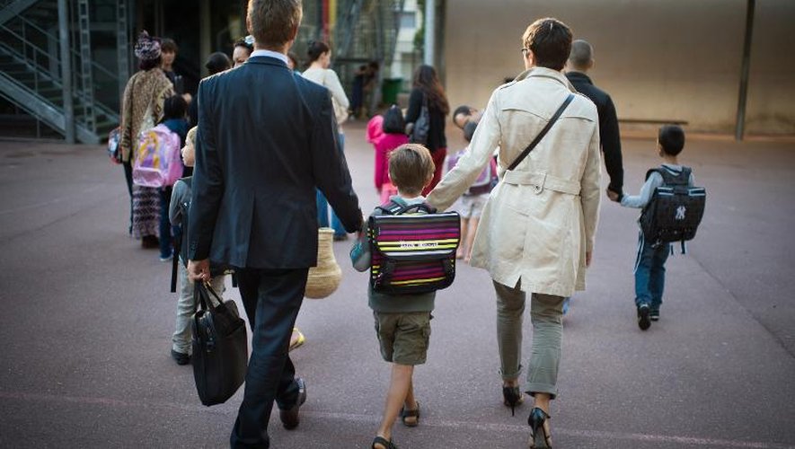 Des parents accompagnent leur fils à l'école le jour de la rentrée scolaire le 3 septembre 2013 à Paris