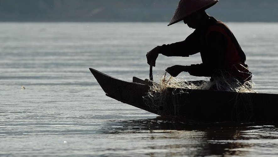 Sur le Mékong, près du village de Wiang Kaen, dans la province de Chiang Rai, au nord de la Thaïlande, un pêcheur prépare son filet le 29 mai 2013