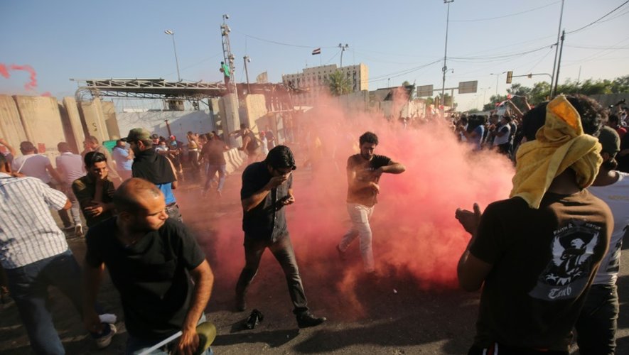 Des manifestants fuient les gaz lacrymogènes lancés par les forces de l'ordre à Bagdad le 20 mai 2016