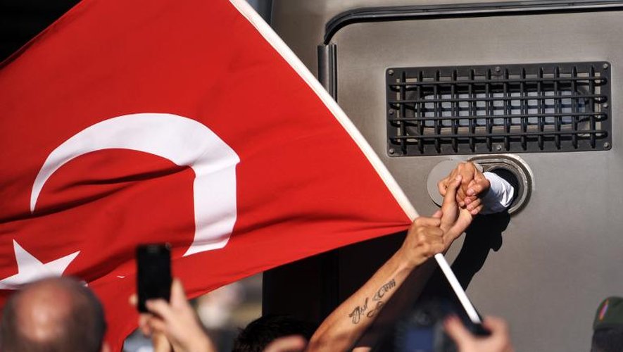 Un manifestant serre la main de l'un des accusés du procès des membres du réseau putschiste Ergenekon, transporté dans un véhicule blindé, à Silivri, près d'Instanbul, le 5 août 2013