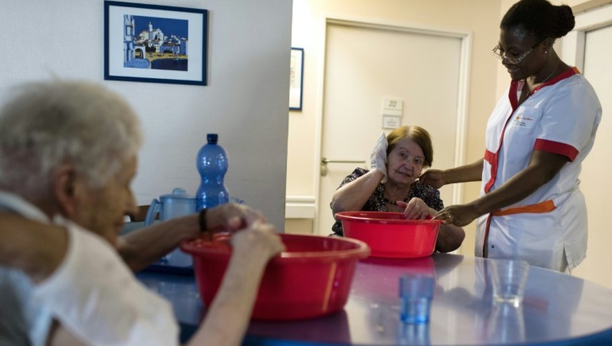Une infirmière aide des personnes âgées à se rafraîchir dans un EHPAD à Lyon le 2 juillet 2015
