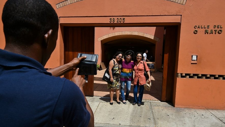 Des touristes posent devant la maison de l'écrivain Gabriel Garcia Marquez à Carthagène le 22 mai 2016