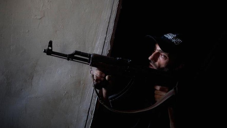 Un rebelle syrien vise un groupe de militaires pro-Assad, le 9 juillet 2013 à Alep